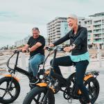 Un couple de retraités snowbirds sur des vélos électriques au bord de la plage