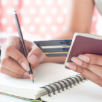 Une dame vérifie les couvertures de son assurance voyage incluse sur sa carte de crédit.